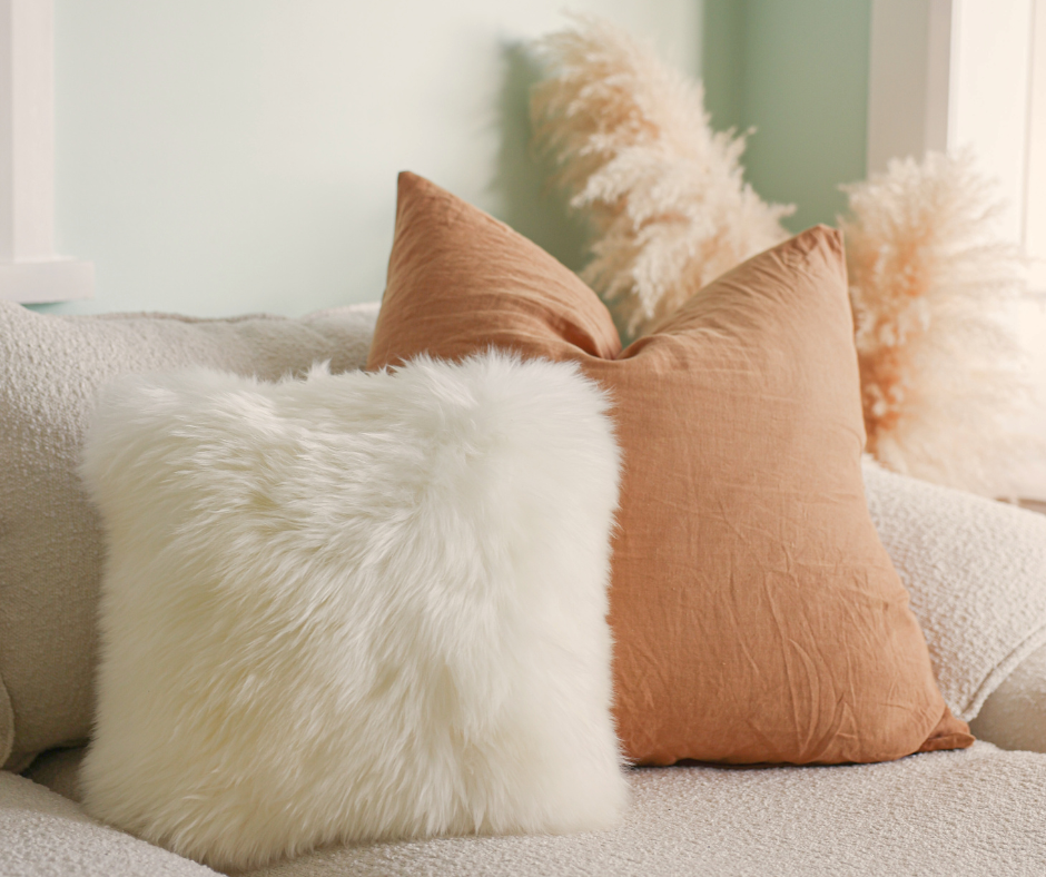 Natural white double-sided sheepskin cushion on a sofa