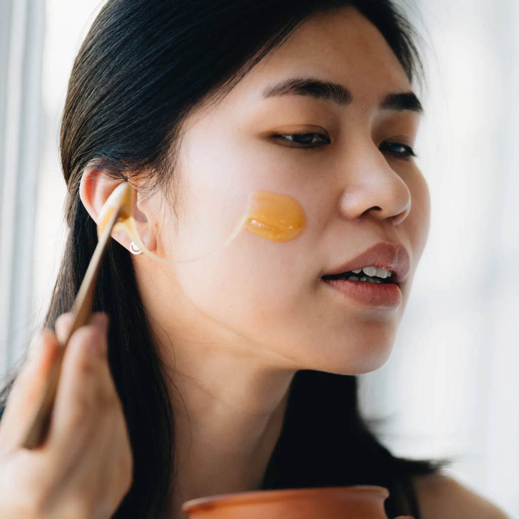Person applying mānuka honey to their cheek