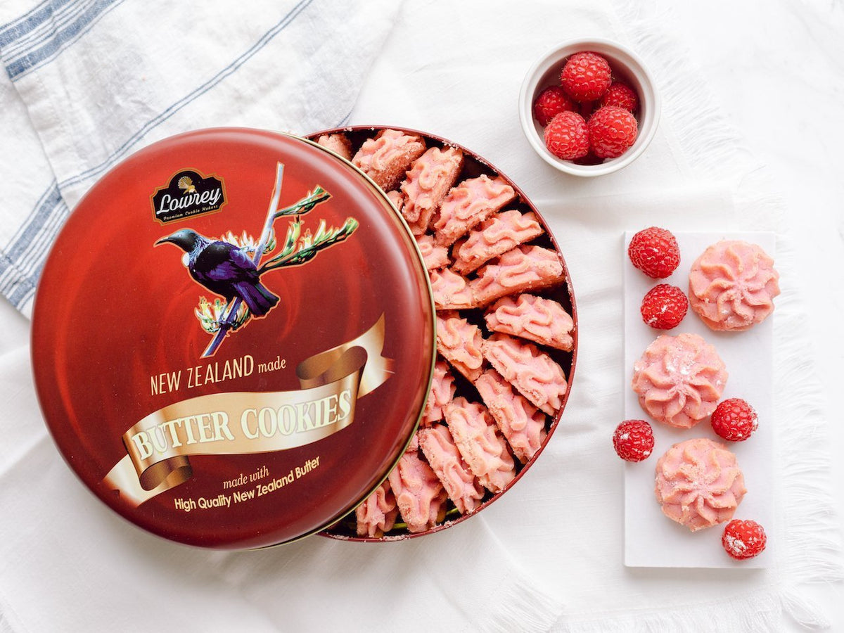 Open tin of Lowrey Raspberry butter cookies with fresh raspberries