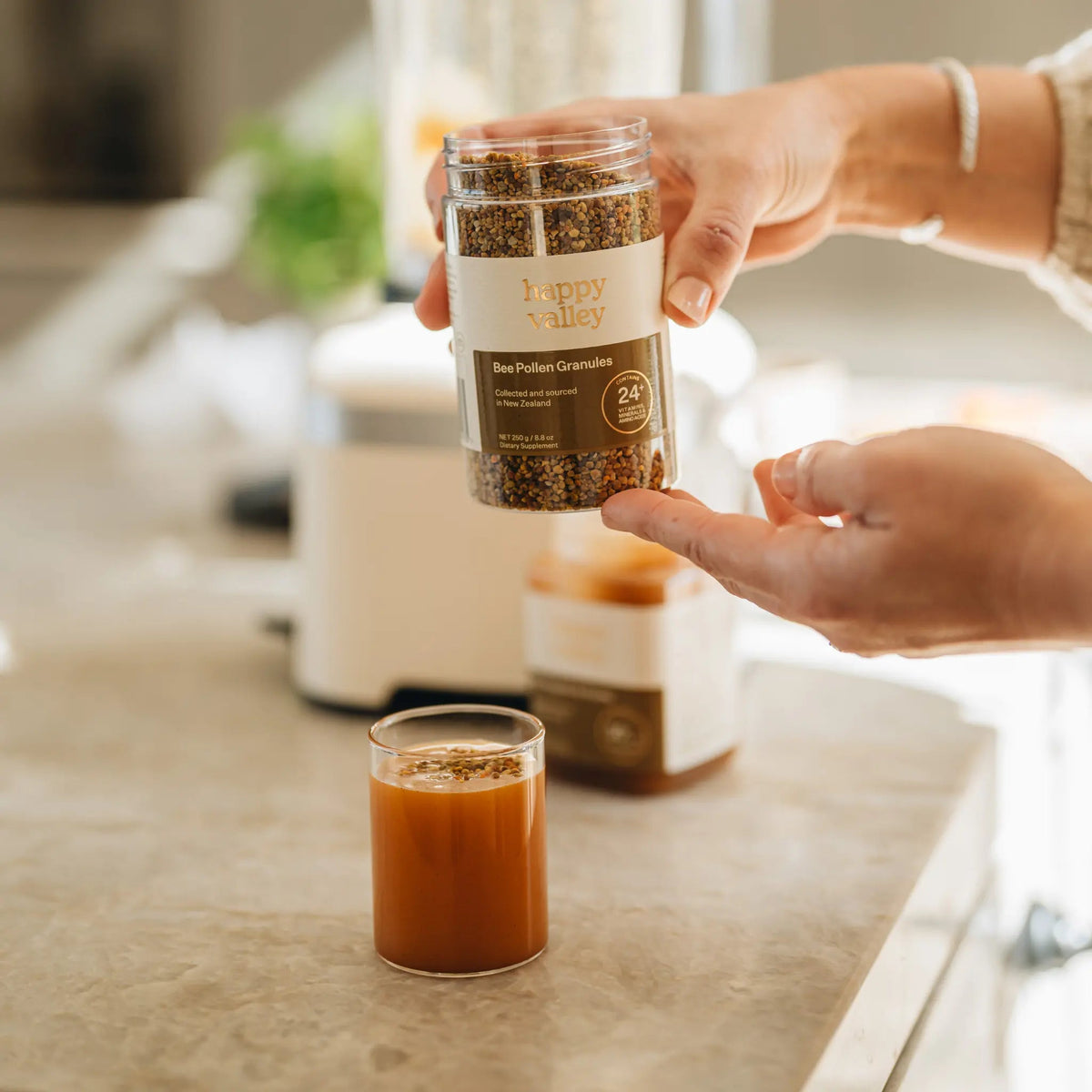 Bee pollen granules being spooned into a drink