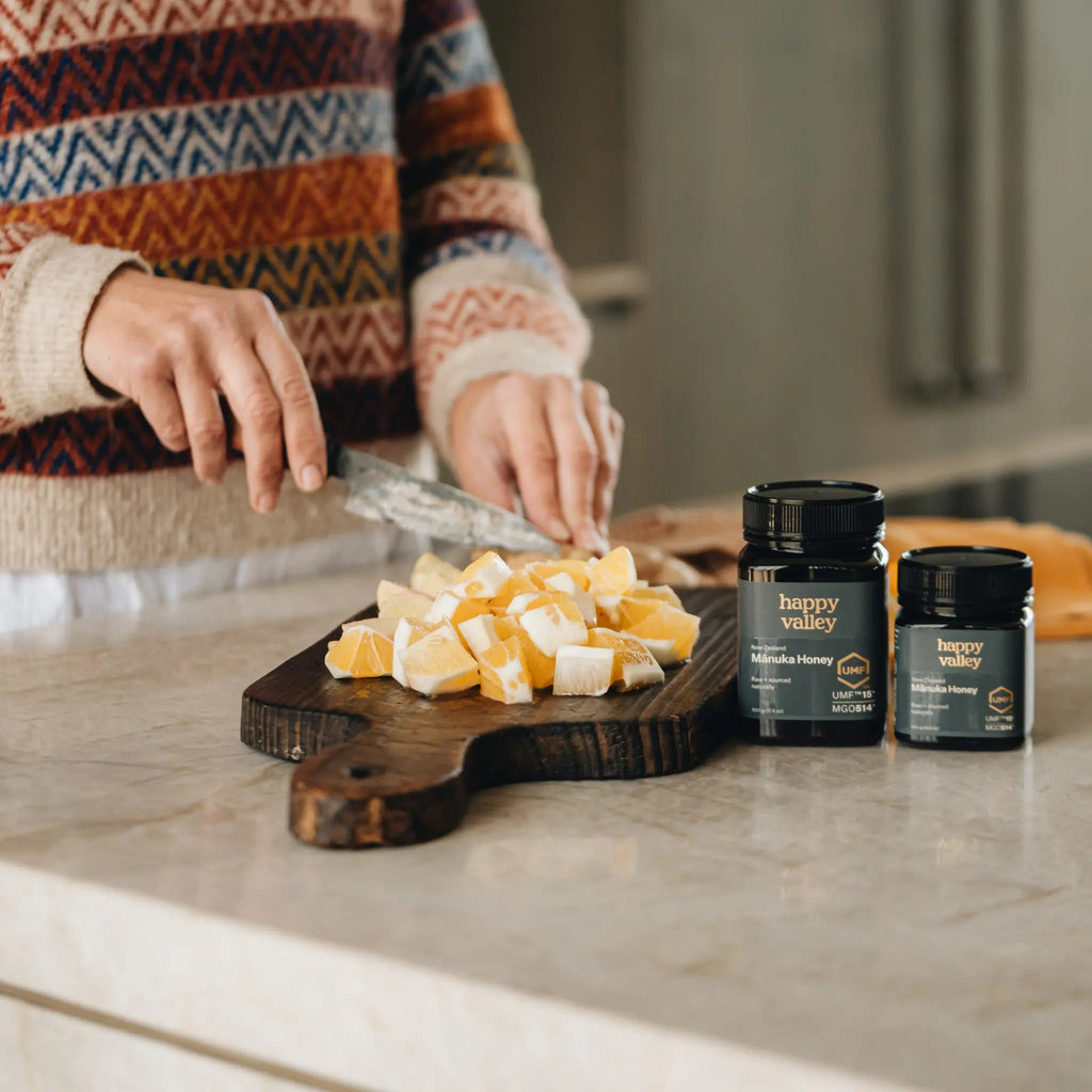 Happy Valley Mānuka Honey jars on a bench with chopped ginger
