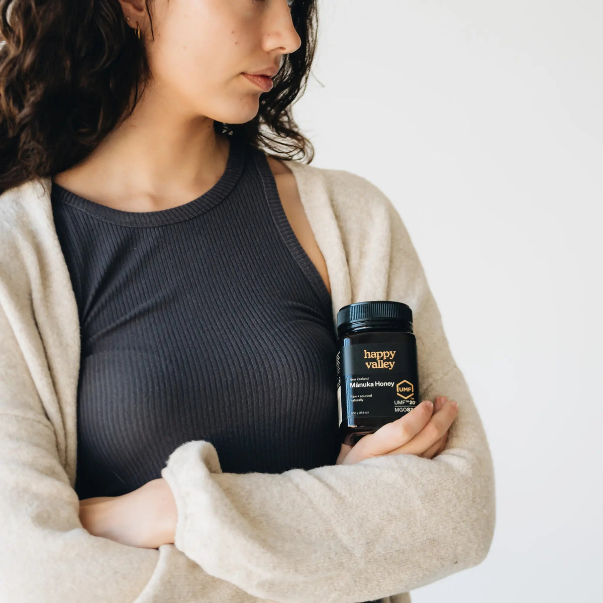 Person holding a jar of Happy Valley Mānuka Honey UMF 20+