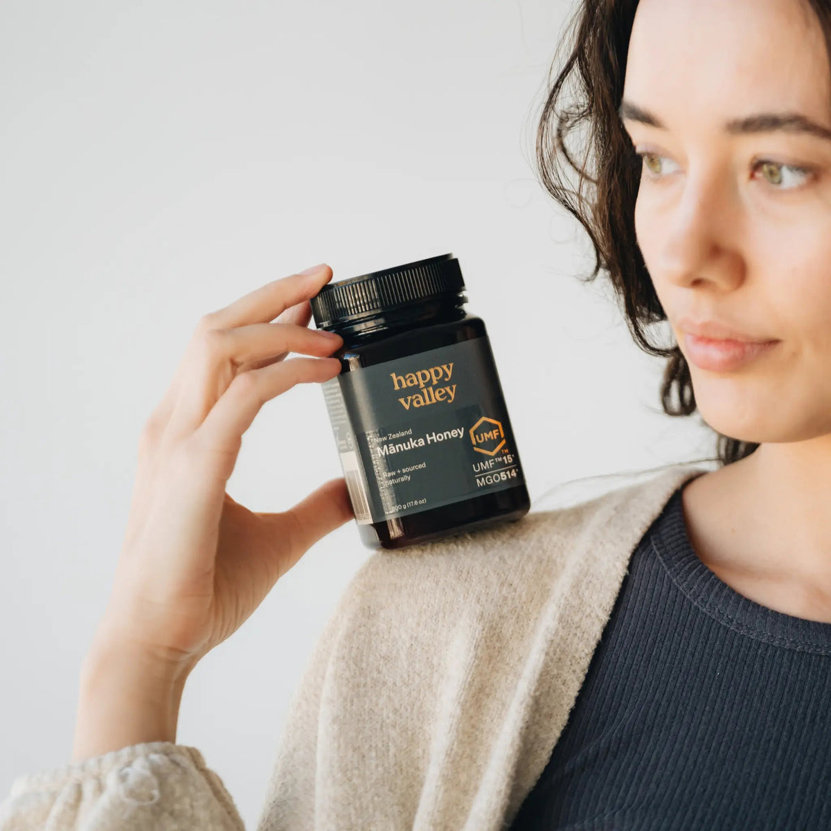 Person holding a jar of Happy Valley Mānuka Honey UMF 15+
