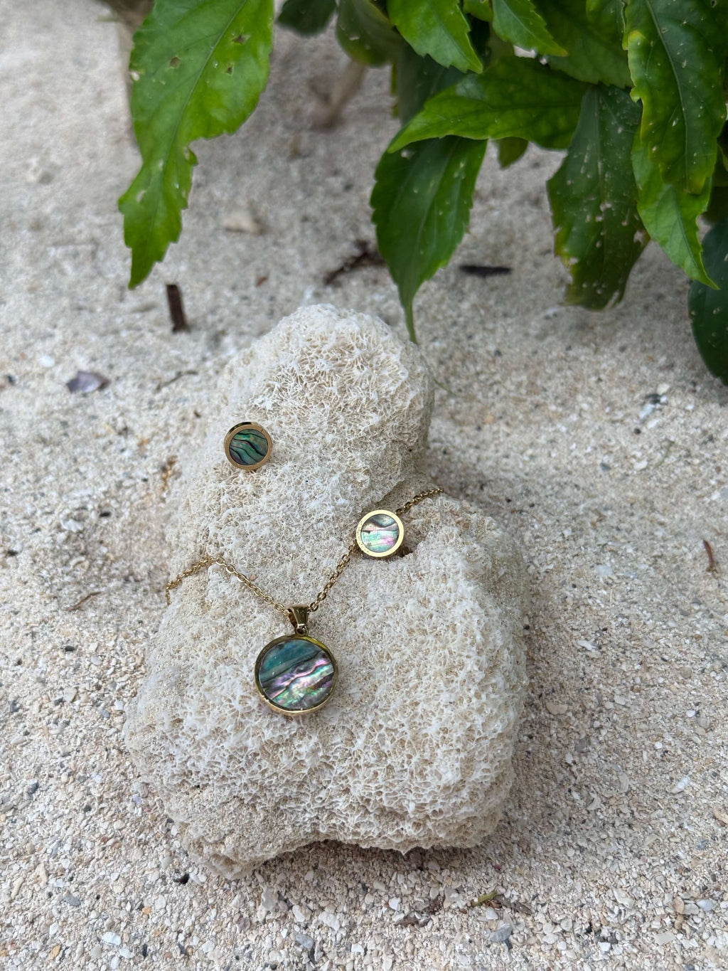 Pītau Moana Set pāua necklace and earrings on a stone