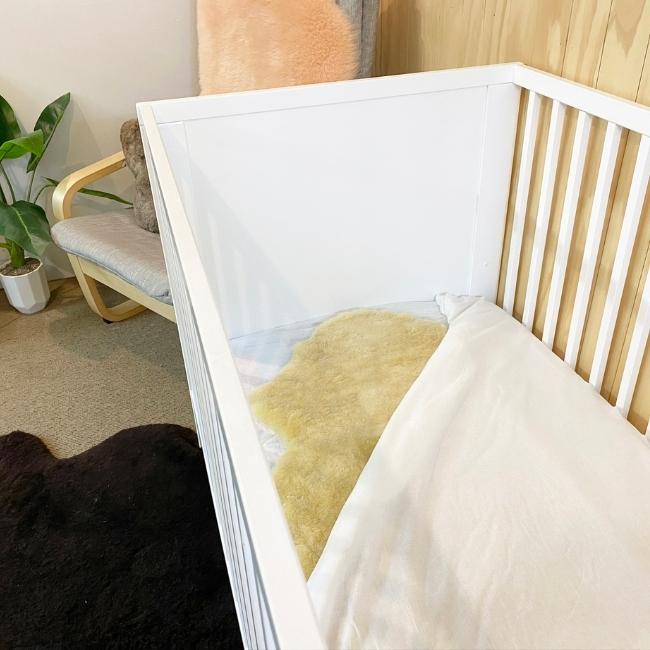 Sleep Sheepskin Baby Rug in a white cot