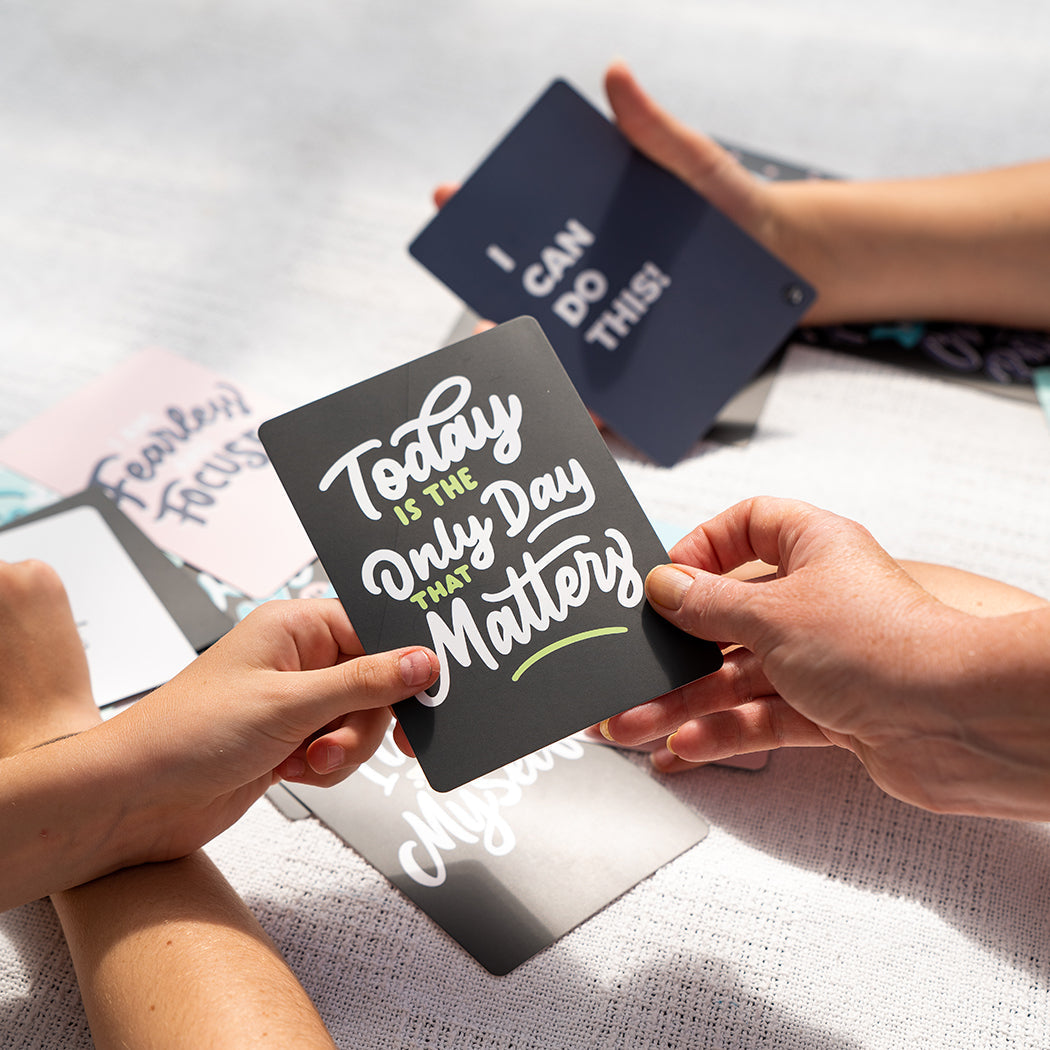 Hands holding Positive Affirmations cards