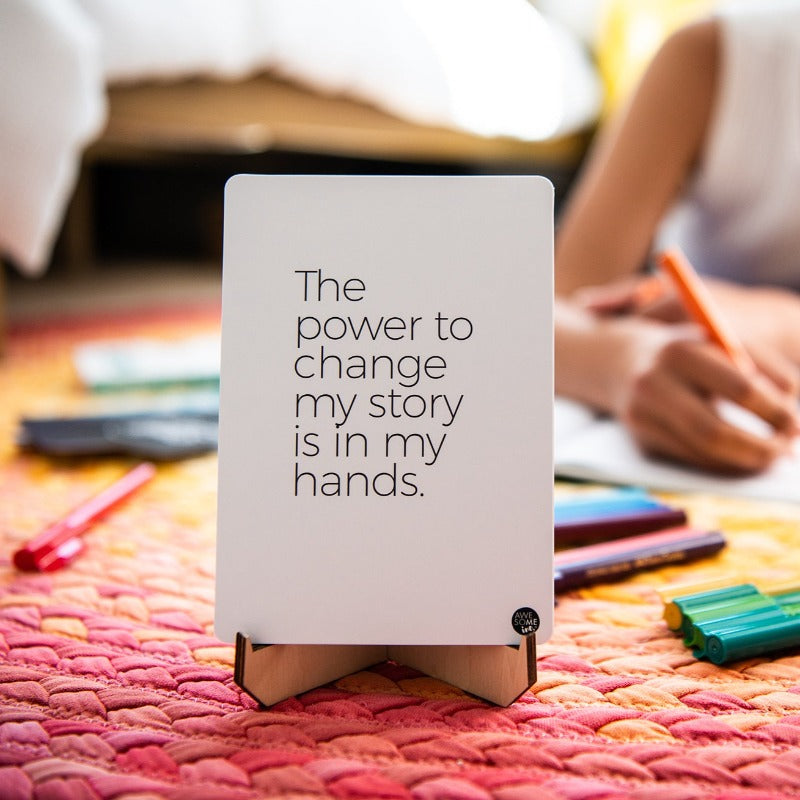 Positive Affirmations card reading "The power to change my story is in my hands" on a stand
