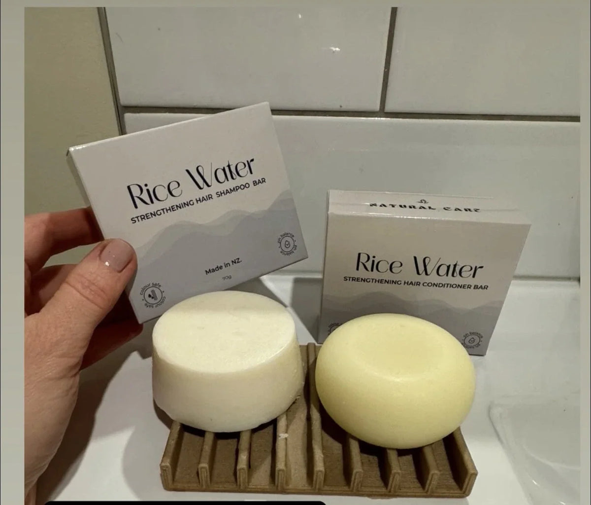 Hand holding NaturalCare Rice Water box with bars on a soap dish