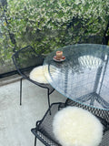 Natural white round sheepskin seat pads on outdoor chairs