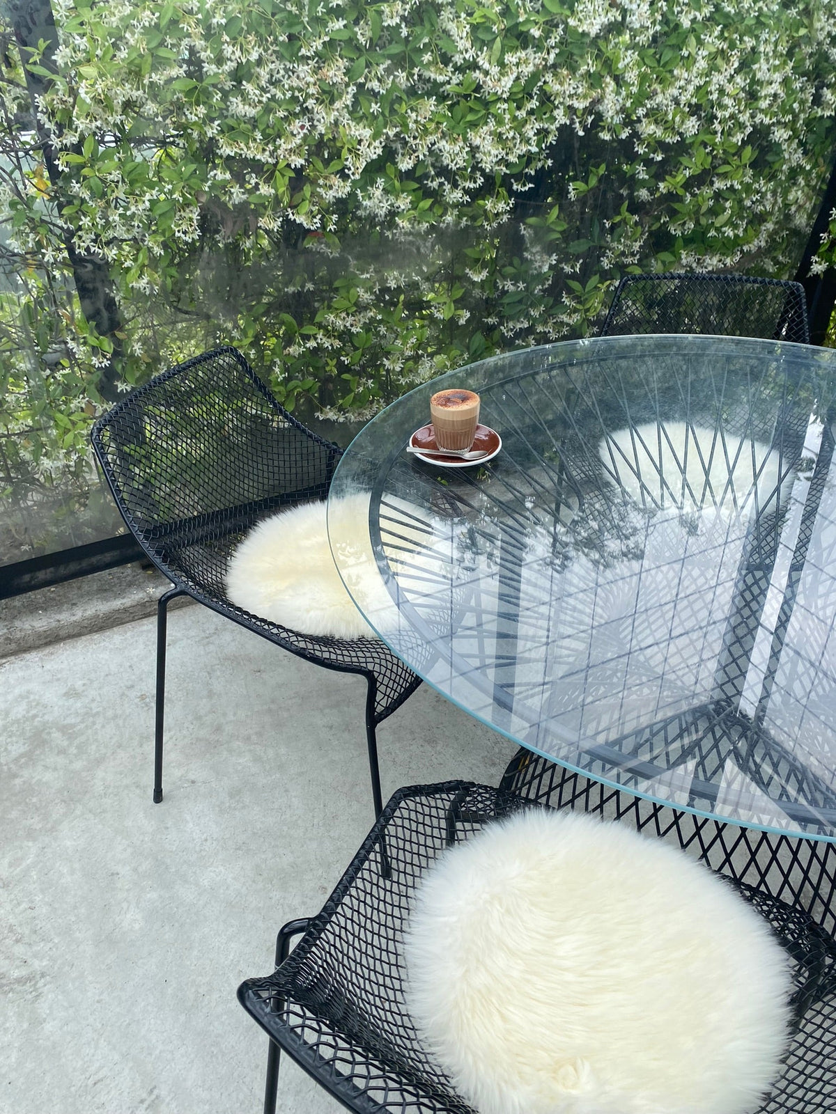 Natural white round sheepskin seat pads on outdoor chairs