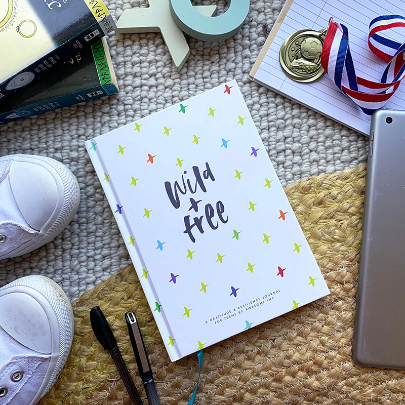 Resilient ME "Wild + Free" teen journal on a desk