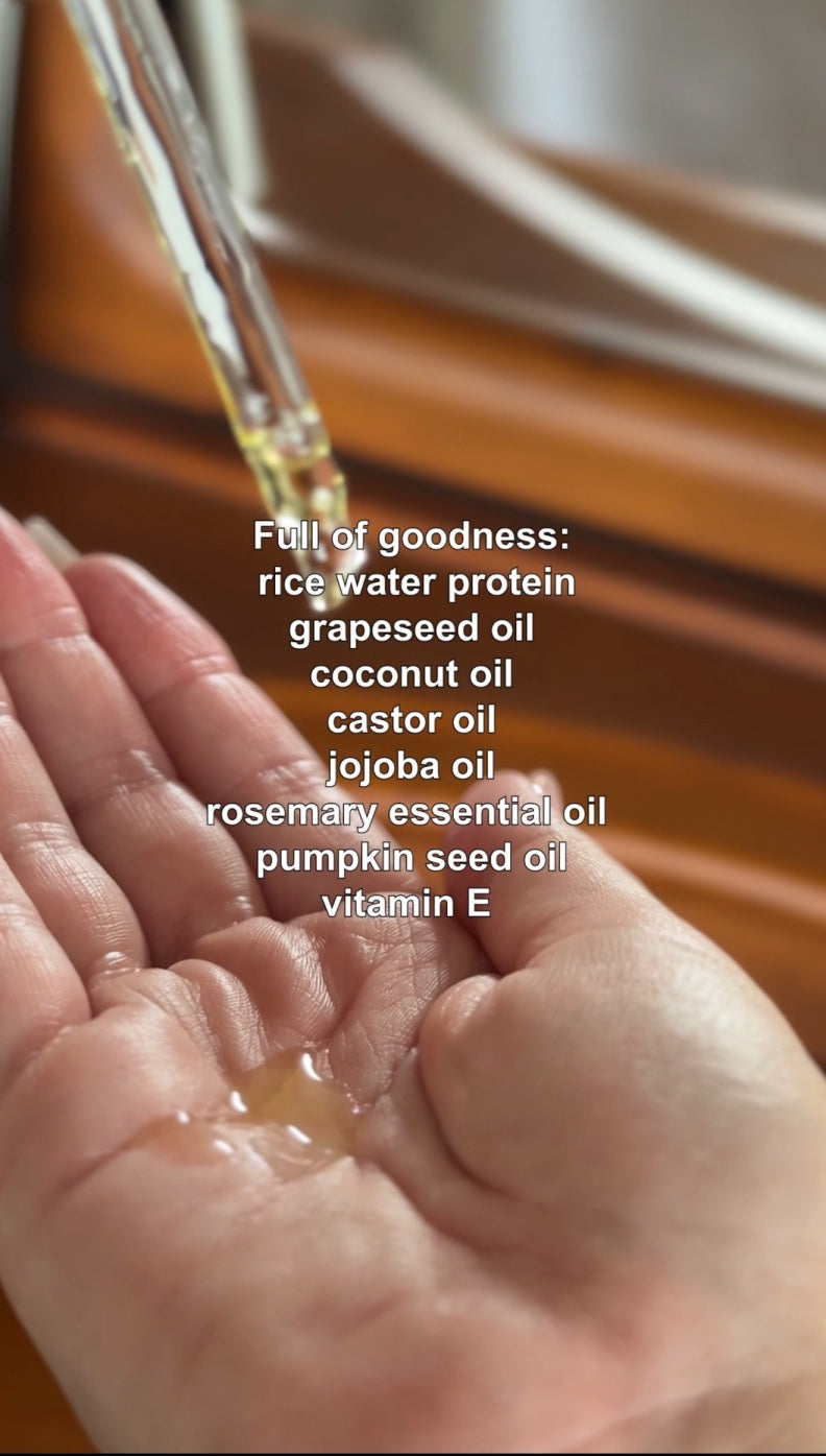 Drop of hair oil on a palm with ingredient list