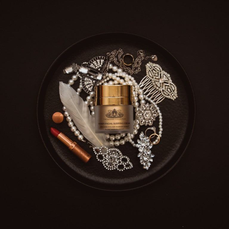 Honey Facial Sleeping Cream jar on a black plate with jewellery