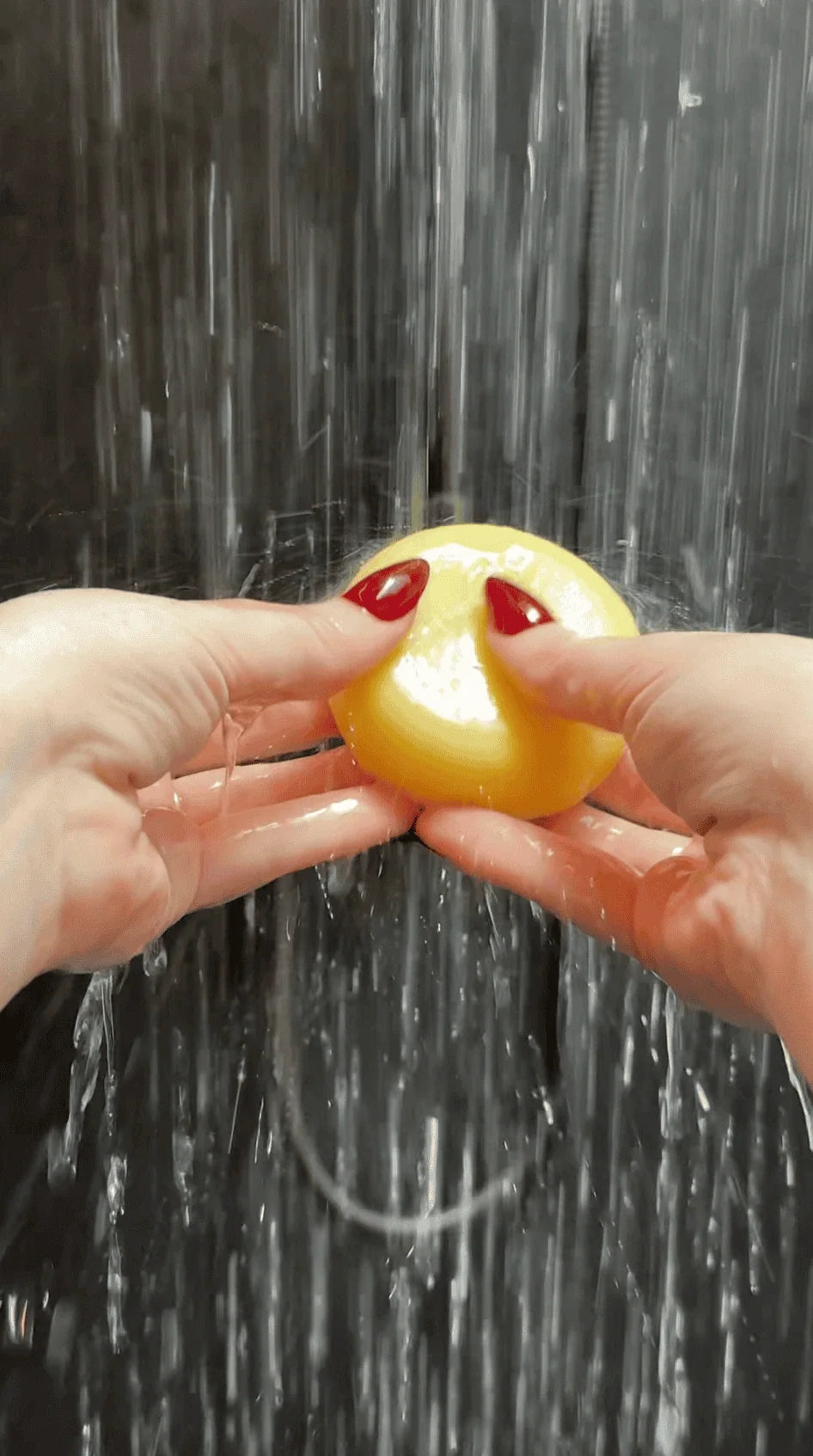 Hands holding a NaturalCare shampoo bar under running water