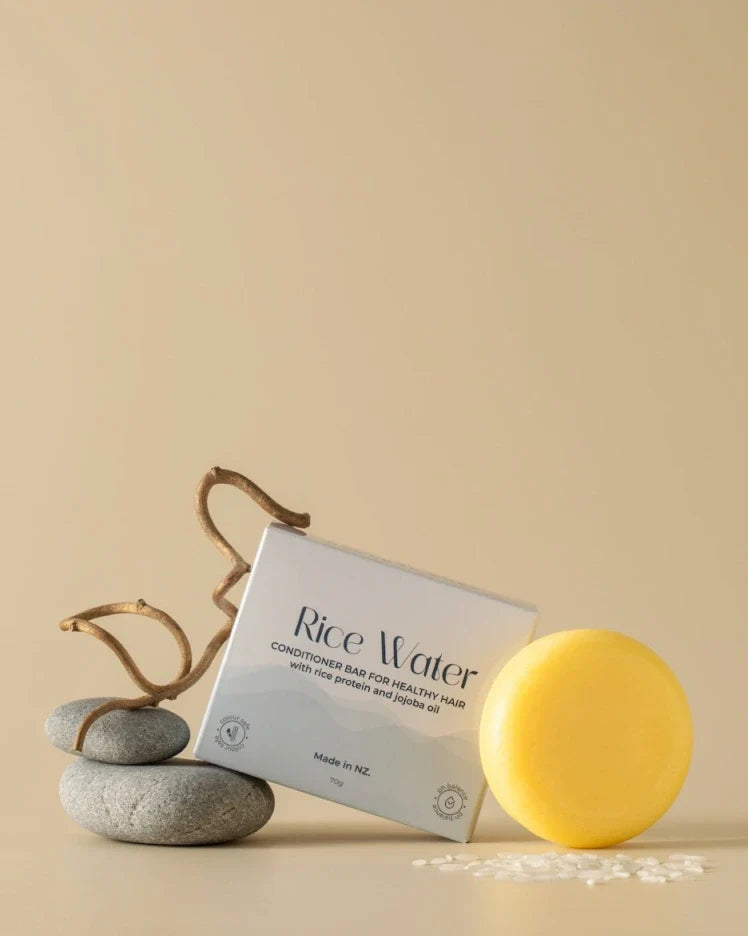 NaturalCare Rice Water shampoo and conditioner bars on stones