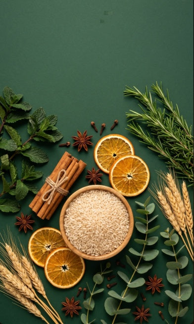 Flat lay of bowl of rice, dried orange slices and cinnamon with greenery