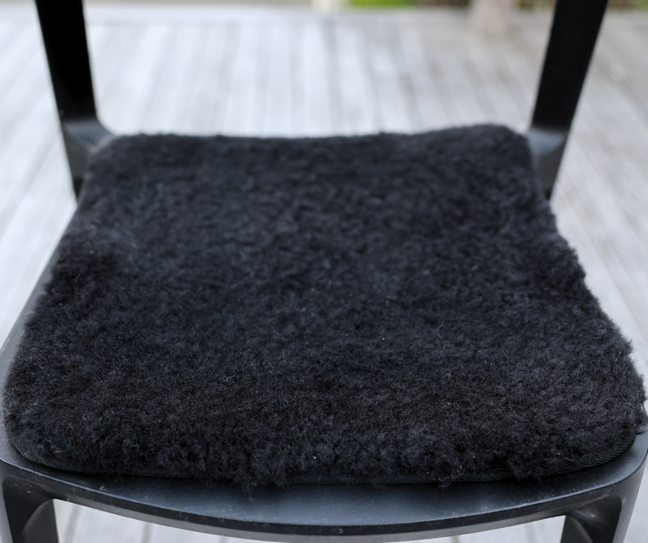 Black square short-wool sheepskin seat pad on a chair