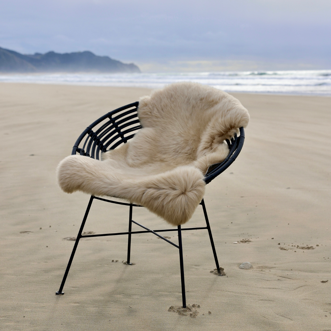 Sand single sheepskin rug over a chair on a beach