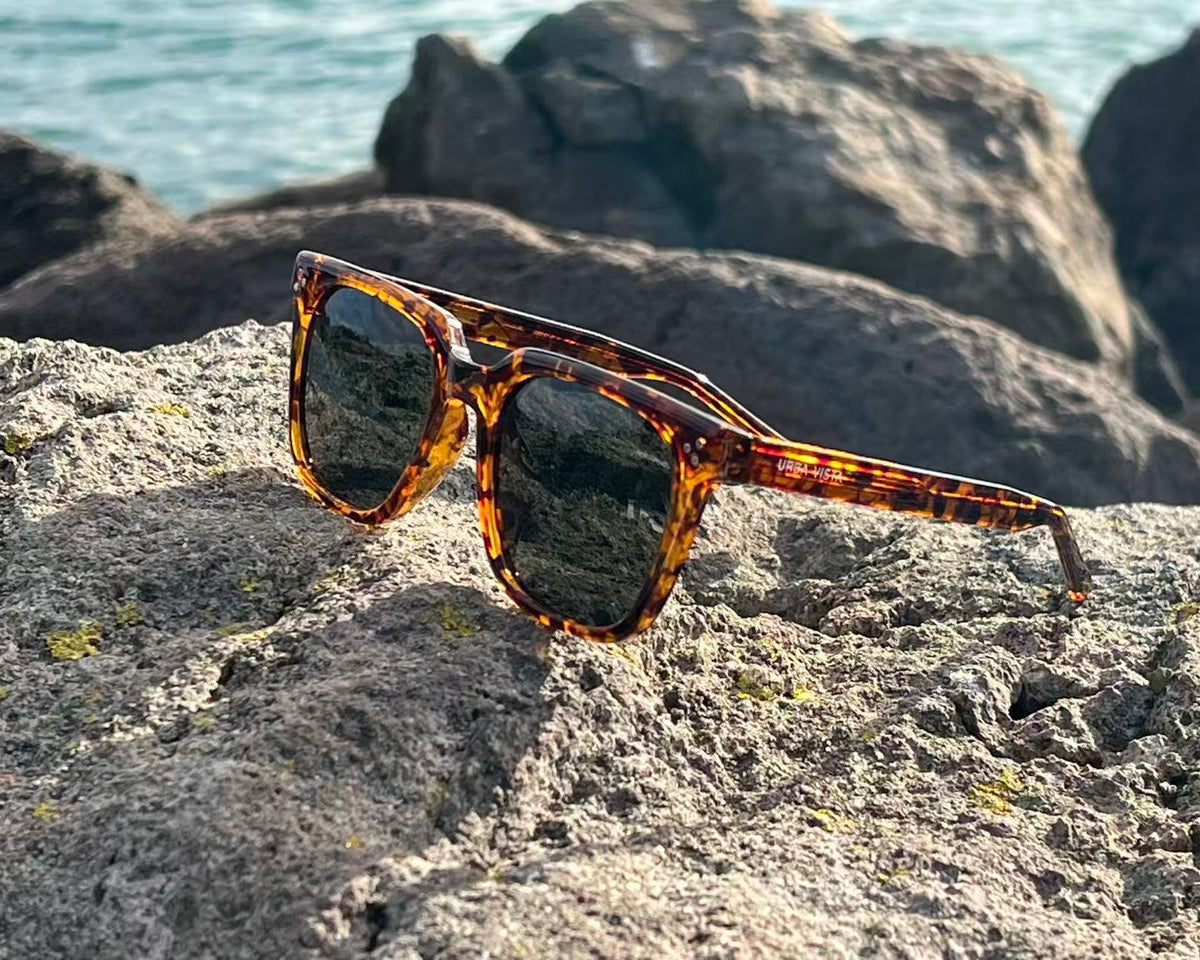 URBA VISTA Titan tortoiseshell sunglasses resting on a rock by the sea