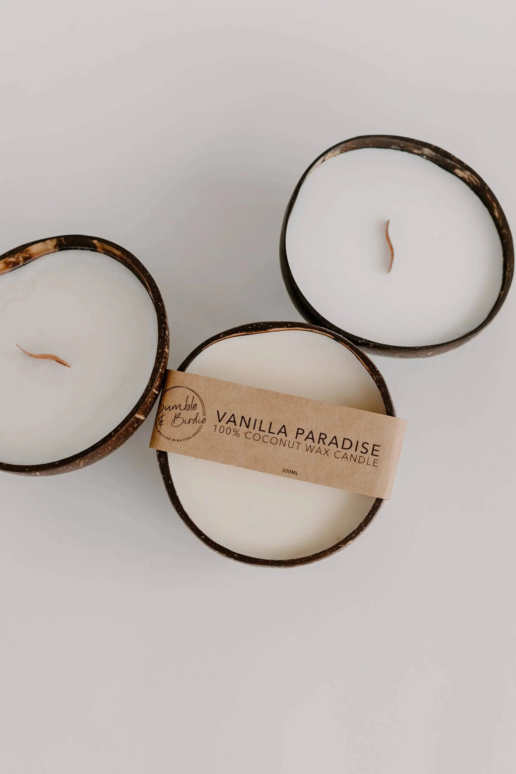 Three Vanilla Paradise coconut shell candles with wood wicks