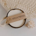 Vanilla Paradise pure coconut candle in a coconut shell with a Bumble & Birdie label, on a woven fan
