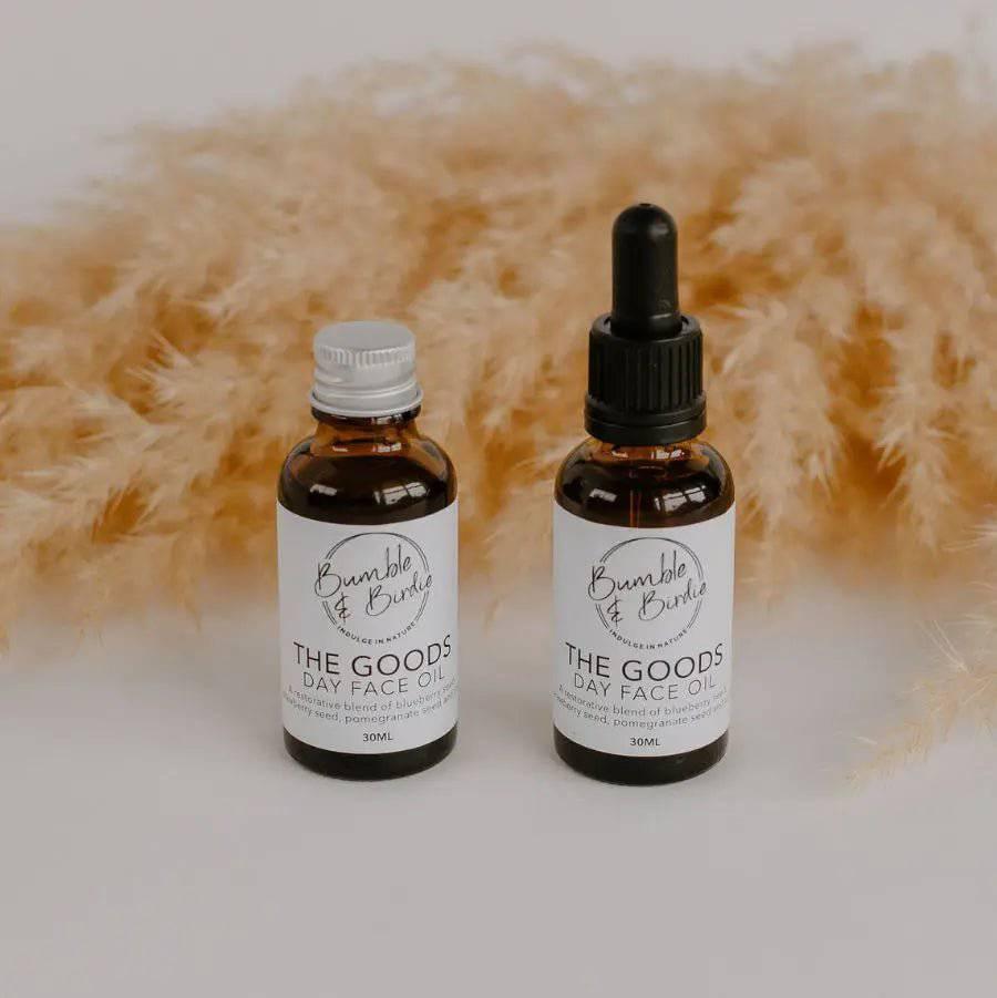 The Goods day face oil in a refill bottle and a dropper bottle by Bumble & Birdie, with pampas grass