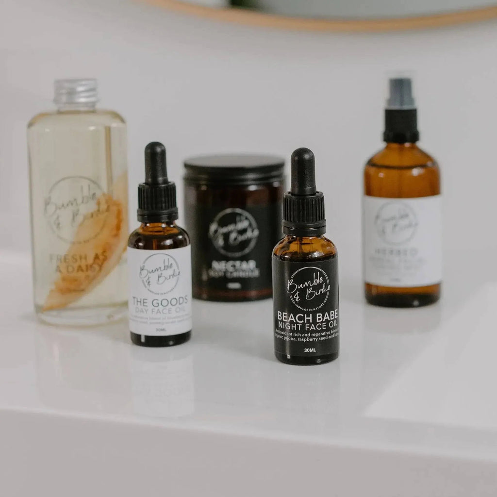 Close-up of the Winter Revival set: body oil, face oils, Nectar candle and mist bottle
