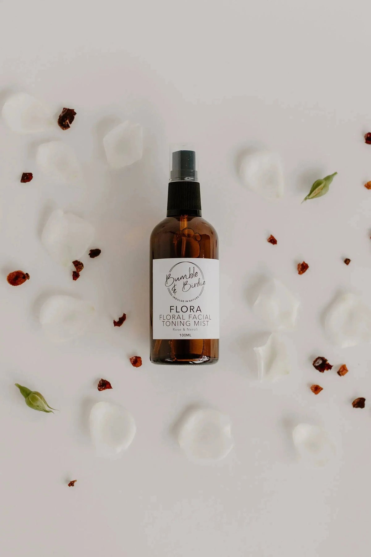 Flora facial toning mist bottle from the Winter Revival set among white petals
