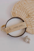 Candy Shop pure coconut candle in a coconut shell with a Bumble & Birdie label, on a woven mat