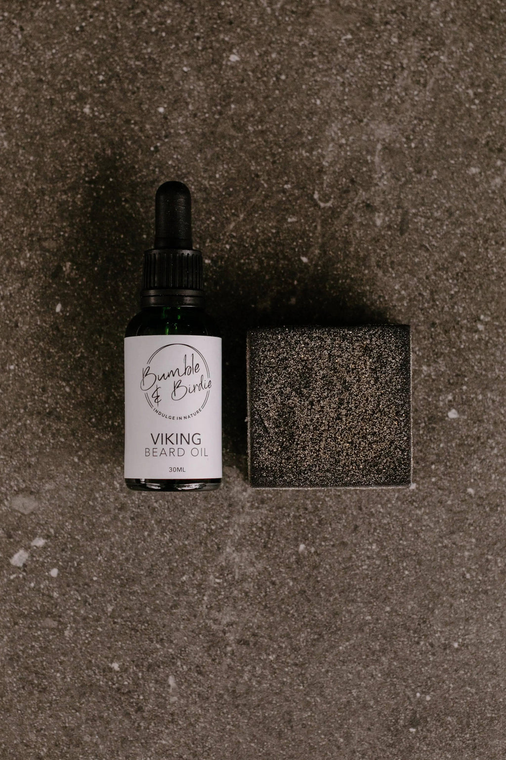 Elixir Master Beard Ritual Set: Viking beard oil beside a black clay shaving bar