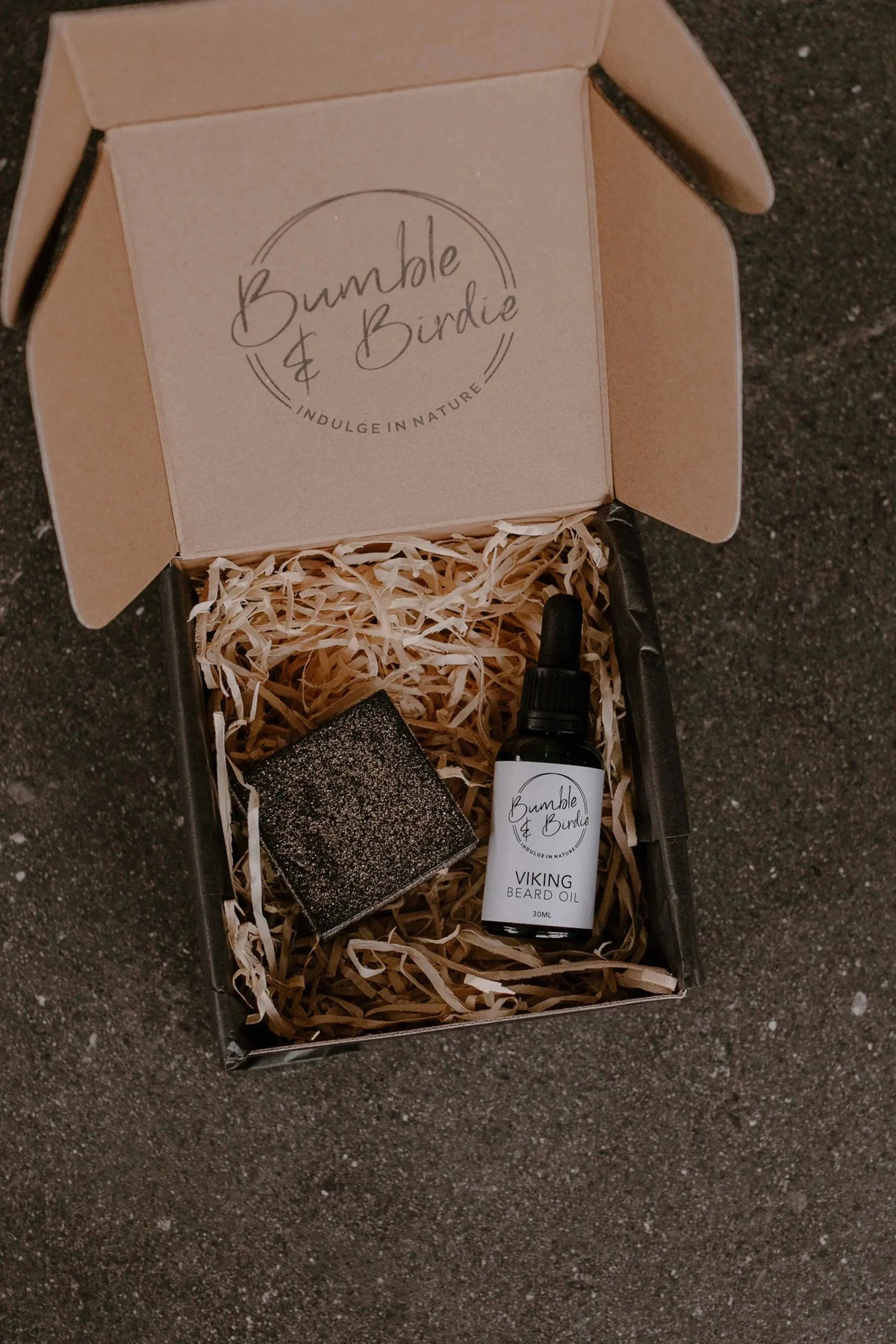 Elixir Master Beard Ritual Set in an open Bumble & Birdie box with beard oil and a shaving bar