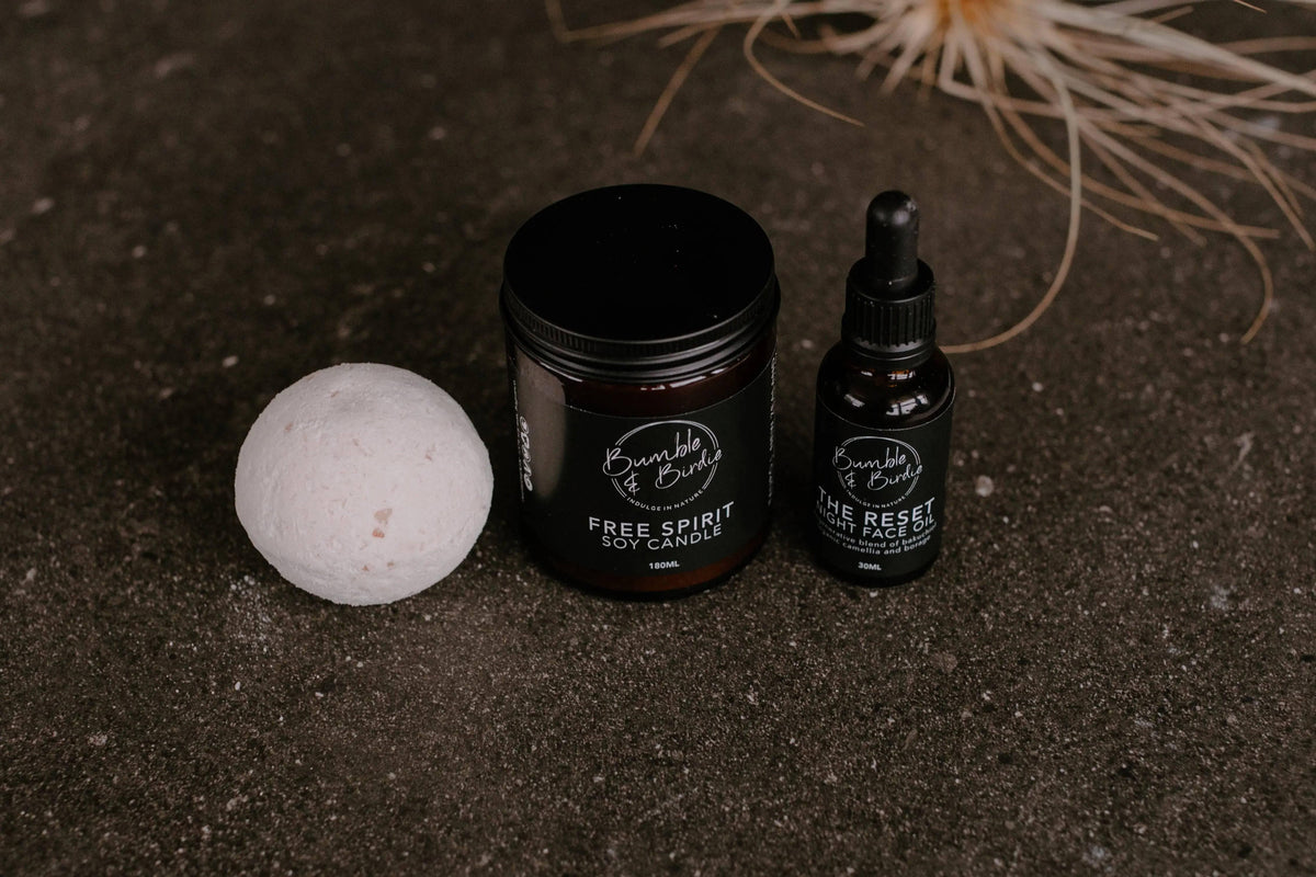 Autumn Reset set laid out: bath bomb, jar candle and The Reset night face oil