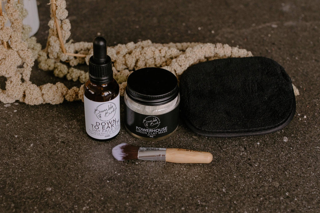 Powerhouse Ritual Set laid out: face oil, green clay mask jar, microfibre sponge and mini mask brush