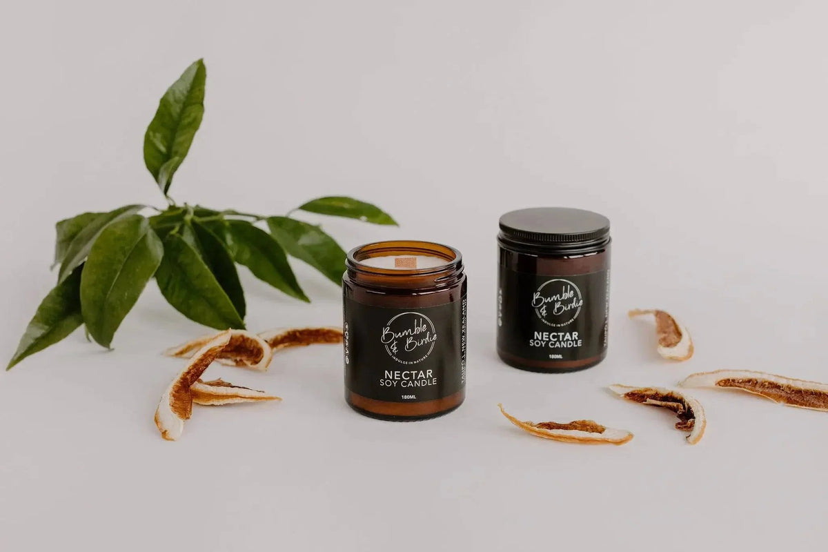 Two Nectar soy jar candles from the Summer Daze set with leaves and dried orange