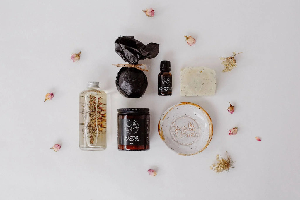 The Art of Bath Ritual Set laid out: body oil, jar candle, essential oil, soap dish and body bar