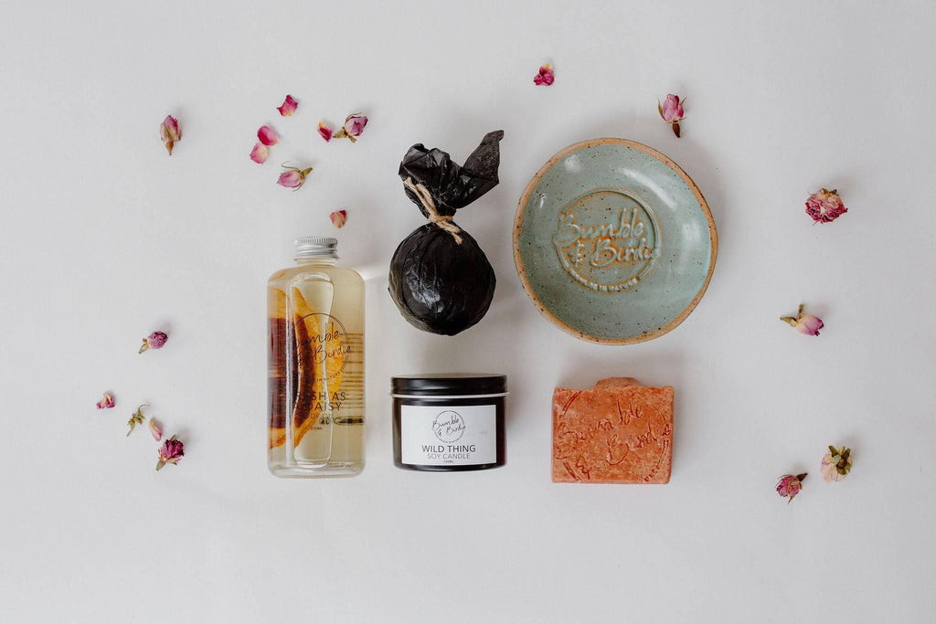 The Art of Shower set laid out: shower oil, shower bomb, tin candle, body bar and soap dish