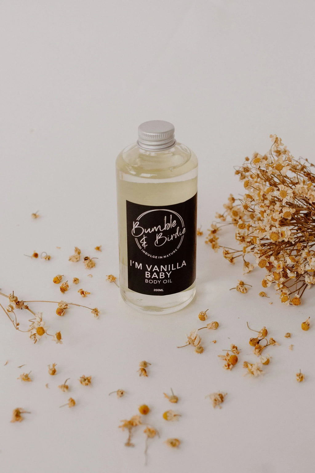 Im Vanilla Baby bath and body oil in a clear bottle by Bumble & Birdie, with dried flowers