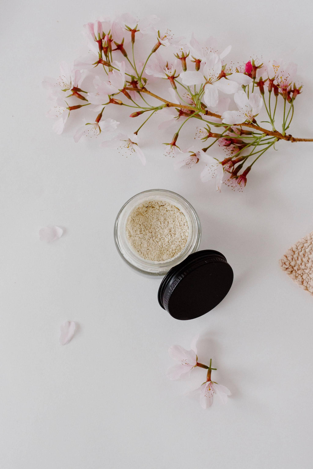 Open jar of T-Warrior white clay mask powder with pink blossom