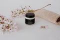 Jar of T-Warrior White Clay Mask by Bumble & Birdie with pink blossom and a knitted cloth