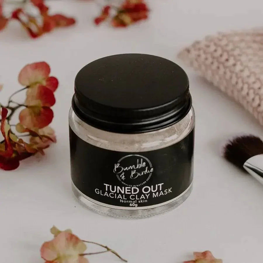 Jar of Tuned Out Glacial Clay Mask by Bumble & Birdie with dried flowers and a knitted cloth