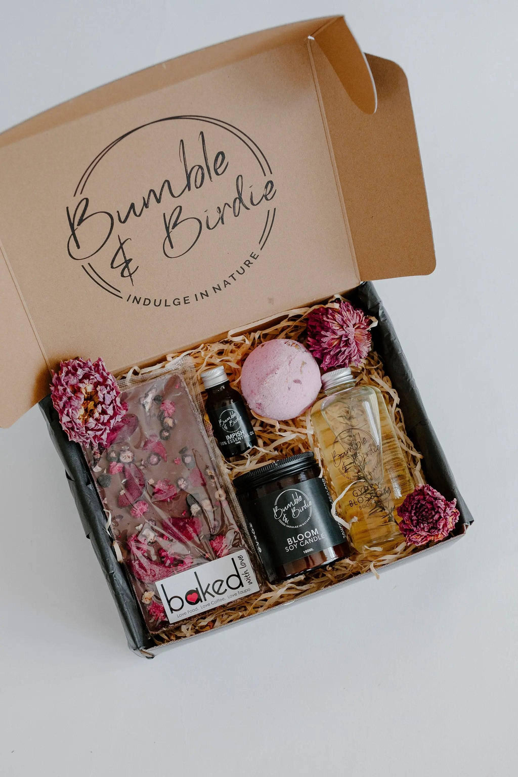 Lovers Lane Gift Set in an open Bumble & Birdie box with a jar candle, body oil, bath bomb and chocolate