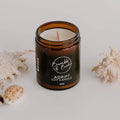 Adrift soy candle in an amber glass jar by Bumble & Birdie, with shells