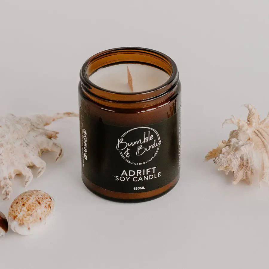 Adrift soy candle in an amber glass jar by Bumble & Birdie, with shells