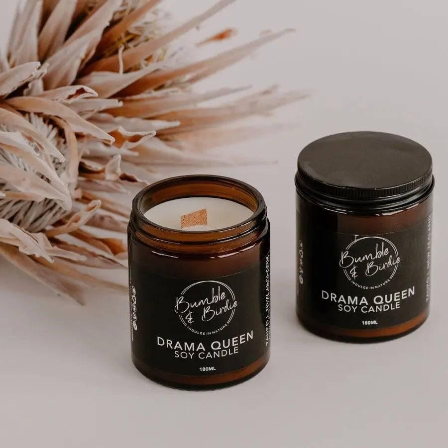 Two Drama Queen soy jar candles by Bumble & Birdie, one open, with dried protea