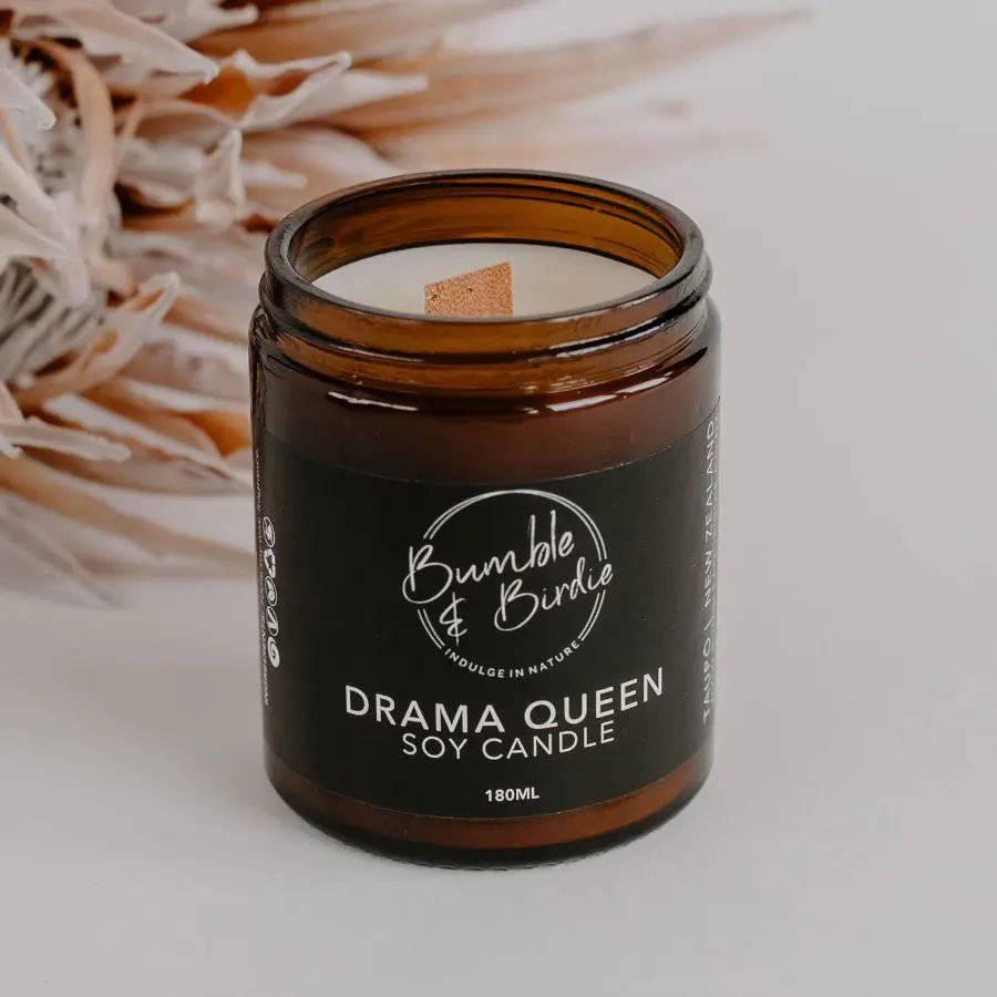 Close-up of a Drama Queen soy candle in an amber glass jar