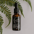 Into the Ngahere night serum in a dropper bottle by Bumble & Birdie, against green ferns