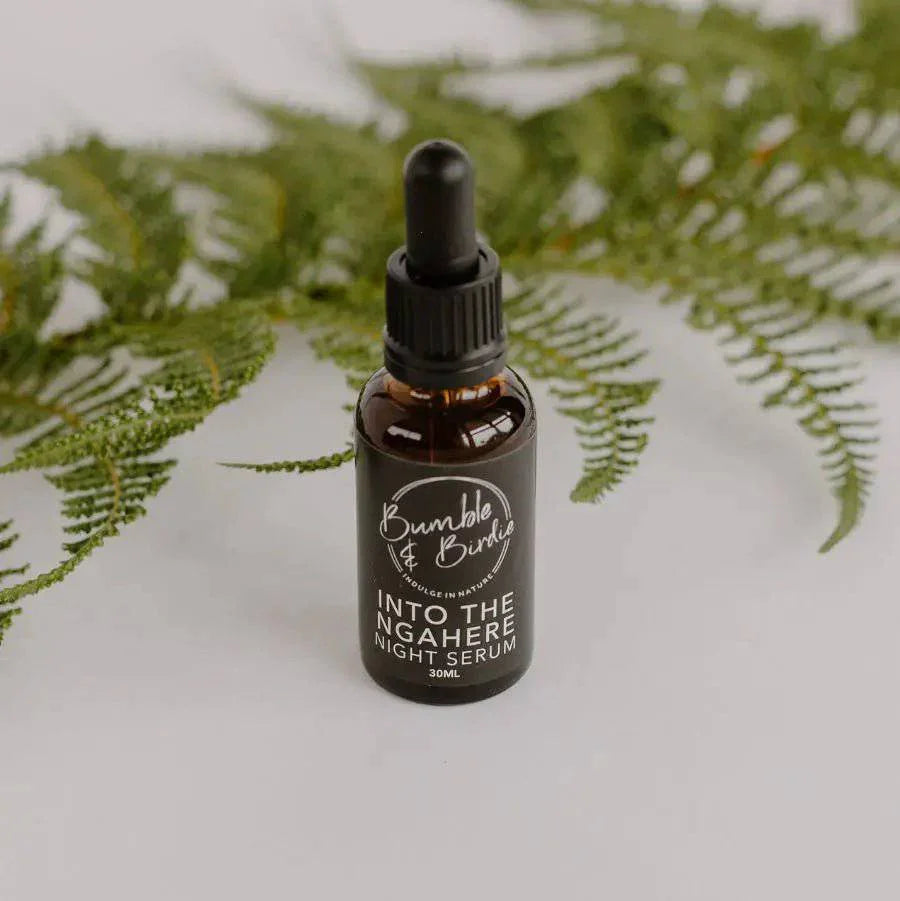 Into the Ngahere night serum dropper bottle in front of a fern frond