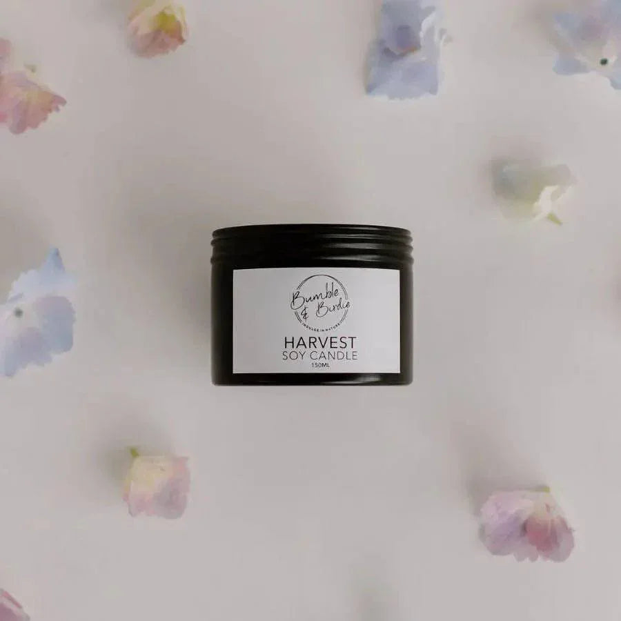 Harvest soy tin candle from above, surrounded by hydrangea petals