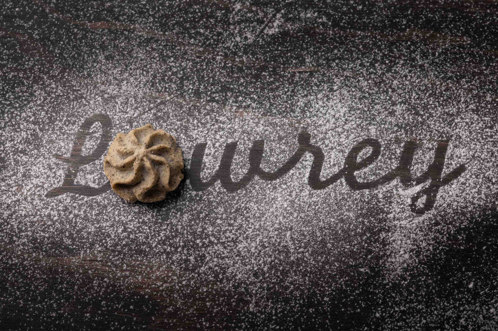 Lowrey Black Sesame butter cookie on black sesame seeds with the Lowrey name written in flour