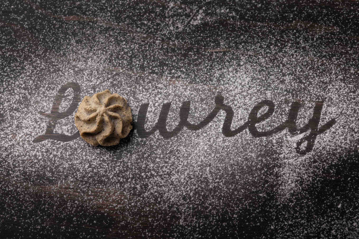 Lowrey Black Sesame butter cookie on black sesame seeds with the Lowrey name written in flour